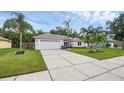Landscaped home with a two-car garage, long driveway and well manicured lawn at 705 Sunburst Cove Ln, Winter Garden, FL 34787
