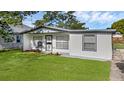 Attractive home with a white exterior, tidy landscaping, and a lush green lawn at 7612 Pomelo Dr, Orlando, FL 32819