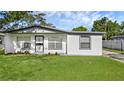 Charming single-story home featuring white exterior paint, gray trim, and a well-manicured lawn at 7612 Pomelo Dr, Orlando, FL 32819