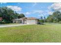 Well maintained one-story home with green lawn, large driveway and mature trees at 929 Louvre Ct, Kissimmee, FL 34759