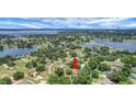Picturesque aerial shot of the property nestled among lush trees, near a lake, showcasing its serene location at 10697 Lake Hill Dr, Clermont, FL 34711