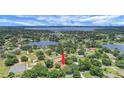 Picturesque aerial shot of the property nestled among lush trees, near a lake, showcasing its serene location at 10697 Lake Hill Dr, Clermont, FL 34711