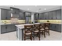 Stylish kitchen featuring gray cabinetry, stainless steel appliances, quartz countertops, and island with seating at 1224 Hillcrest View Loop, Apopka, FL 32703