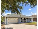 Charming single-story home showcasing a well-maintained lawn, two car garage and inviting arched windows at 13848 Vista Del Lago Blvd, Clermont, FL 34711