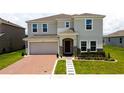 Charming two-story home features a brick driveway, two-car garage, and a well-manicured lawn at 1588 Sky Lakes Dr, St Cloud, FL 34769