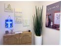 A contemporary interior with a decorative cabinet, stylish decor, and a tall potted plant adding a touch of nature at 1588 Sky Lakes Dr, St Cloud, FL 34769