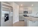 Modern kitchen featuring stainless steel appliances, gray cabinetry, and a spacious island for cooking and entertaining at 172 S Zuni Rd, St Cloud, FL 34771