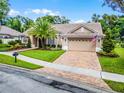 Attractive single-Gathering home showcasing a tile roof, two-car garage, and neatly kept front lawn with mature trees at 174 Promenade Cir, Lake Mary, FL 32746