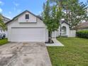 A charming one-story home featuring a two-car garage, fresh exterior paint, and a manicured lawn at 2160 Churchill Downs Cir, Orlando, FL 32825