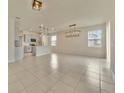 Open-concept living room and kitchen with modern lighting fixtures and tile flooring at 2601 Blowing Breeze Ave, Kissimmee, FL 34744