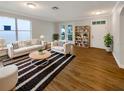 Bright living room with hardwood floors and white furnishings next to large window at 2679 Rainbow Springs Ln, Orlando, FL 32828
