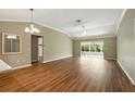 Bright living room with wood-look floors and a sunroom area with expansive windows at 2895 Apache Ct, The Villages, FL 32163