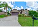 Beautiful single-story home with a well-manicured lawn, and a two-car garage on a sunny day at 30210 Donnington Loop, Mount Dora, FL 32757