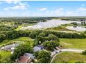 An aerial view of a home nestled by a serene lake surrounded by lush greenery and scenic views at 333 Sonoma Valley Cir, Orlando, FL 32835