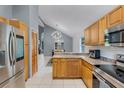 Well-lit kitchen with stainless steel appliances, natural wood cabinetry, and an adjacent dining area at 333 Sonoma Valley Cir, Orlando, FL 32835