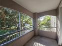 A cozy screened balcony with serene views of lush greenery and glimpses of the tranquil lake at 3446 Soho St # 108, Orlando, FL 32835