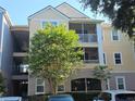 Condo building exterior with multiple floors and a tree in the front at 3446 Soho St # 108, Orlando, FL 32835