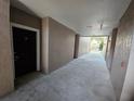 Neutral hallway showcasing entrance door to unit with smooth concrete floors and textured stucco walls at 3446 Soho St # 108, Orlando, FL 32835