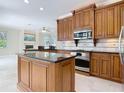 Gourmet kitchen featuring custom wood cabinetry, granite countertops, stainless steel appliances, and center island at 3534 Woodley Park Pl, Oviedo, FL 32765