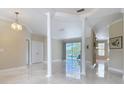 Bright and open living room with columns, neutral walls, and marble flooring that lead to the lanai at 3534 Woodley Park Pl, Oviedo, FL 32765