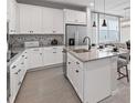 Stylish kitchen featuring white cabinetry, grey countertops and stainless steel appliances at 4409 Lions Gate Ave, Clermont, FL 34711