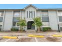 Two-story condominium exterior featuring light grey paint and an entrance with stairs at 4701 S Texas Ave # 4701A, Orlando, FL 32839