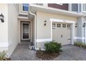 Home's inviting entrance with a brick-paved walkway, featuring a well-maintained front garden and exterior lighting at 4733 Cliveden Loop, Sanford, FL 32773