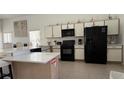 Spacious kitchen with stainless steel appliances, white cabinets, and a large island at 513 Bailey Cir, Davenport, FL 33897