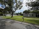 Street view of home featuring a well-manicured lawn and mature trees providing shade at 524 Florida Ave, St Cloud, FL 34769