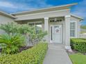 Close-up of a covered front porch with decorative plants and shrubs around the entrance at 5353 Red Leaf Ct, Oviedo, FL 32765