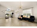 Open-concept living room with modern lighting, neutral decor, and herringbone flooring at 5451 Los Palma Vista Dr, Orlando, FL 32837