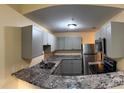 A modern kitchen with granite countertops, new stainless steel appliances, and grey cabinets at 5821 La Costa Dr # 108, Orlando, FL 32807