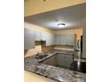 A modern kitchen with granite countertops, new stainless steel appliances, and grey cabinets at 5821 La Costa Dr # 108, Orlando, FL 32807