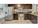 Well-equipped kitchen featuring stainless steel appliances, granite countertops, and stylish dark wood cabinets at 601 Swallow Ct, Apopka, FL 32712
