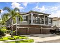 Townhome exterior with a balcony, three car garage, and a well maintained lawn at 6566 S Goldenrod Rd # 82A, Orlando, FL 32822