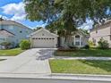 Attractive single-Gathering home boasting a well-kept lawn, two-car garage, and mature shady tree at 6720 Winder Lynne Ln, Orlando, FL 32819