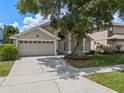 Charming home with a well-maintained lawn, two-car garage, and mature tree shading the facade at 6720 Winder Lynne Ln, Orlando, FL 32819