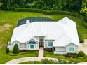 Aerial view of a home featuring a circular driveway, screened-in pool, and well-manicured landscaping at 740 Bear Creek Cir, Winter Springs, FL 32708