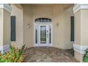 Close-up of the front door, highlighted by decorative glass, sidelights, transom window and brick paver patio at 800 Sterling Chase Dr, Port Orange, FL 32128