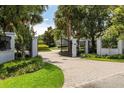 Elegant gated entrance to property with lush landscaping and brick paved driveway at 8542 Eden Park Rd, Orlando, FL 32810