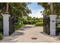 View of the property through open gates, highlighting meticulous landscaping at 8542 Eden Park Rd, Orlando, FL 32810