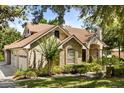 Side view of lovely home with attached garage, manicured landscaping, and brick and stucco exterior at 8800 Torey Pines Ter, Orlando, FL 32819