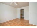 Bedroom with wood-look floors, a ceiling fan, and an ensuite bathroom, offering convenience at 9053 Lee Vista Blvd # 1404, Orlando, FL 32829