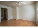 Wood-look floors, a ceiling fan, and two doorways to an ensuite bath and closet at 9053 Lee Vista Blvd # 1404, Orlando, FL 32829