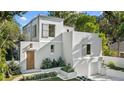 Striking contemporary home with a white exterior, multi-level roofline, and professionally landscaped front yard at 1150 Via Salerno, Winter Park, FL 32789