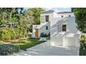 Beautiful white stucco house with two-car garage, perfectly manicured lawn, and mature trees at 1150 Via Salerno, Winter Park, FL 32789