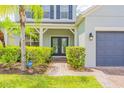 Inviting front entrance with double doors, manicured hedges, and a paved walkway to a two-car garage at 1639 Balsam Willow Trl, Orlando, FL 32825