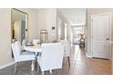 Dining area with white table and chairs leading to a hallway and the front door at 1642 Rock Elm Rd, Davenport, FL 33837