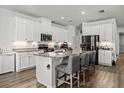 Spacious kitchen with white cabinets, granite countertops, stainless steel appliances, and a large island at 16564 Silversaw Palm Dr, Winter Garden, FL 34787