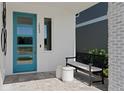Inviting front porch with stylish seating and a modern teal-colored front door at 2042 Education St, St Cloud, FL 34771